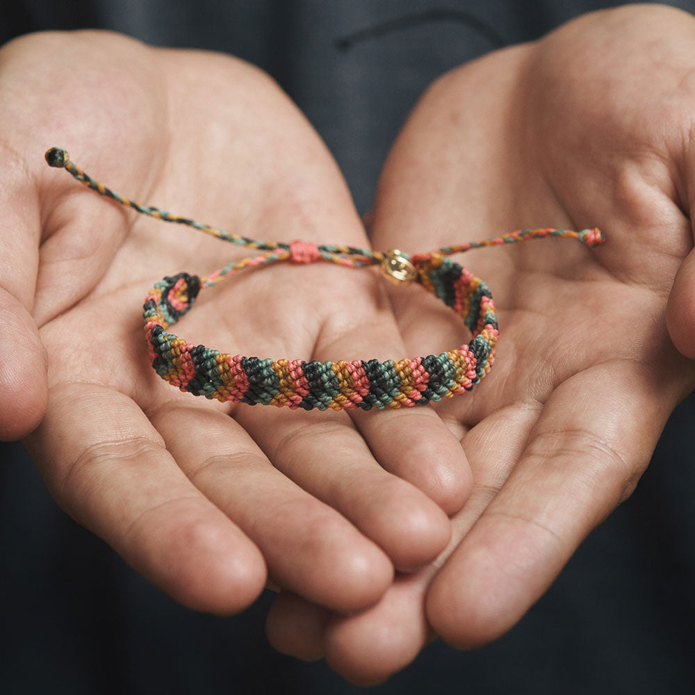 Hands holding a braided bracelet